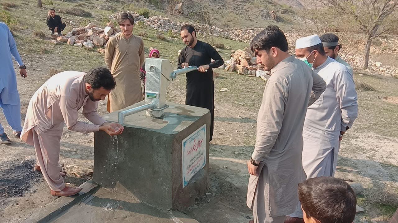 Community members using the new hand pump