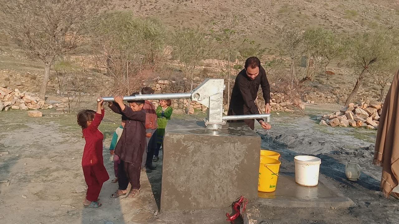 Community members using the new hand pump